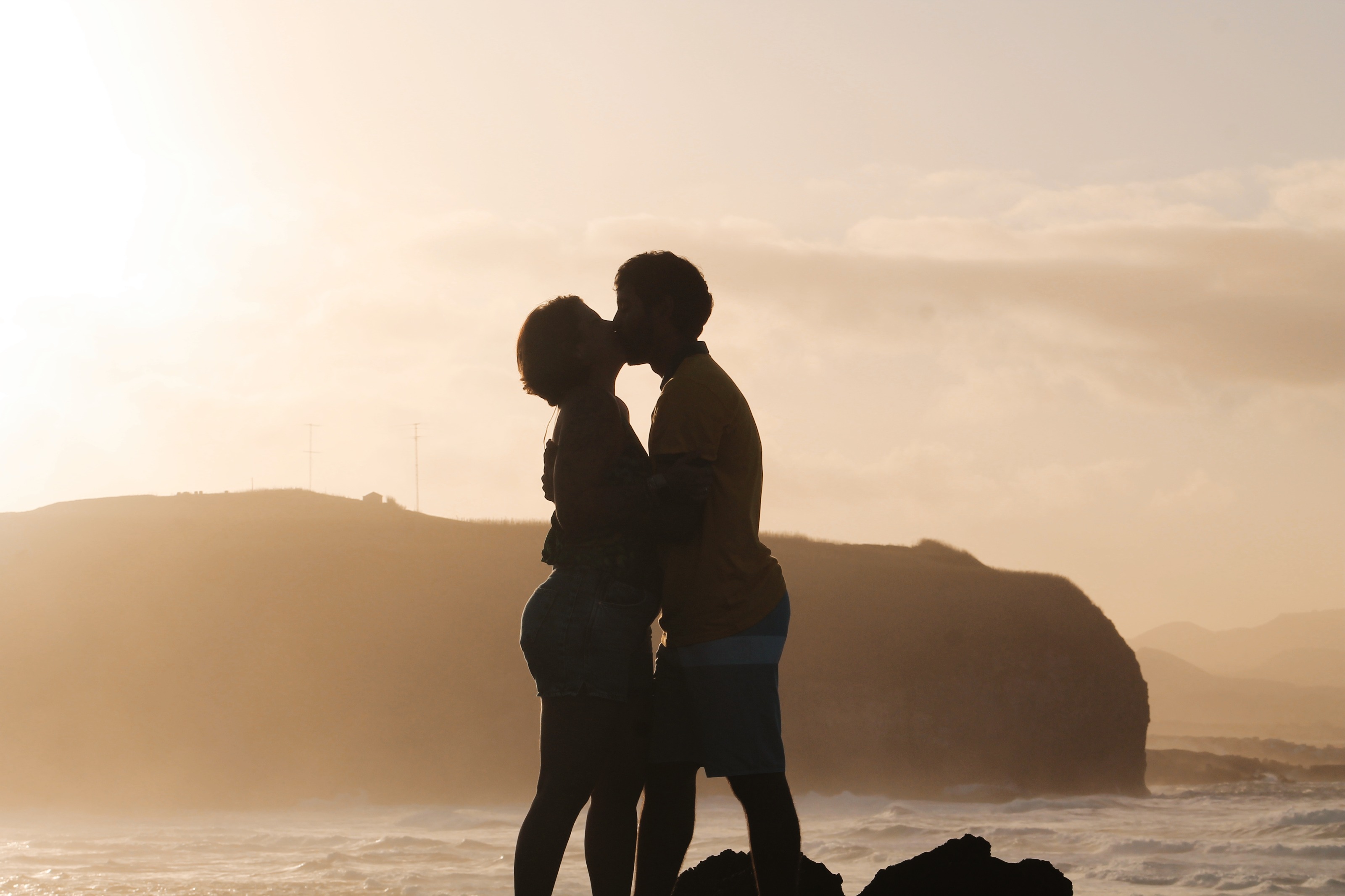 Casal em silhueta ao pôr do sol