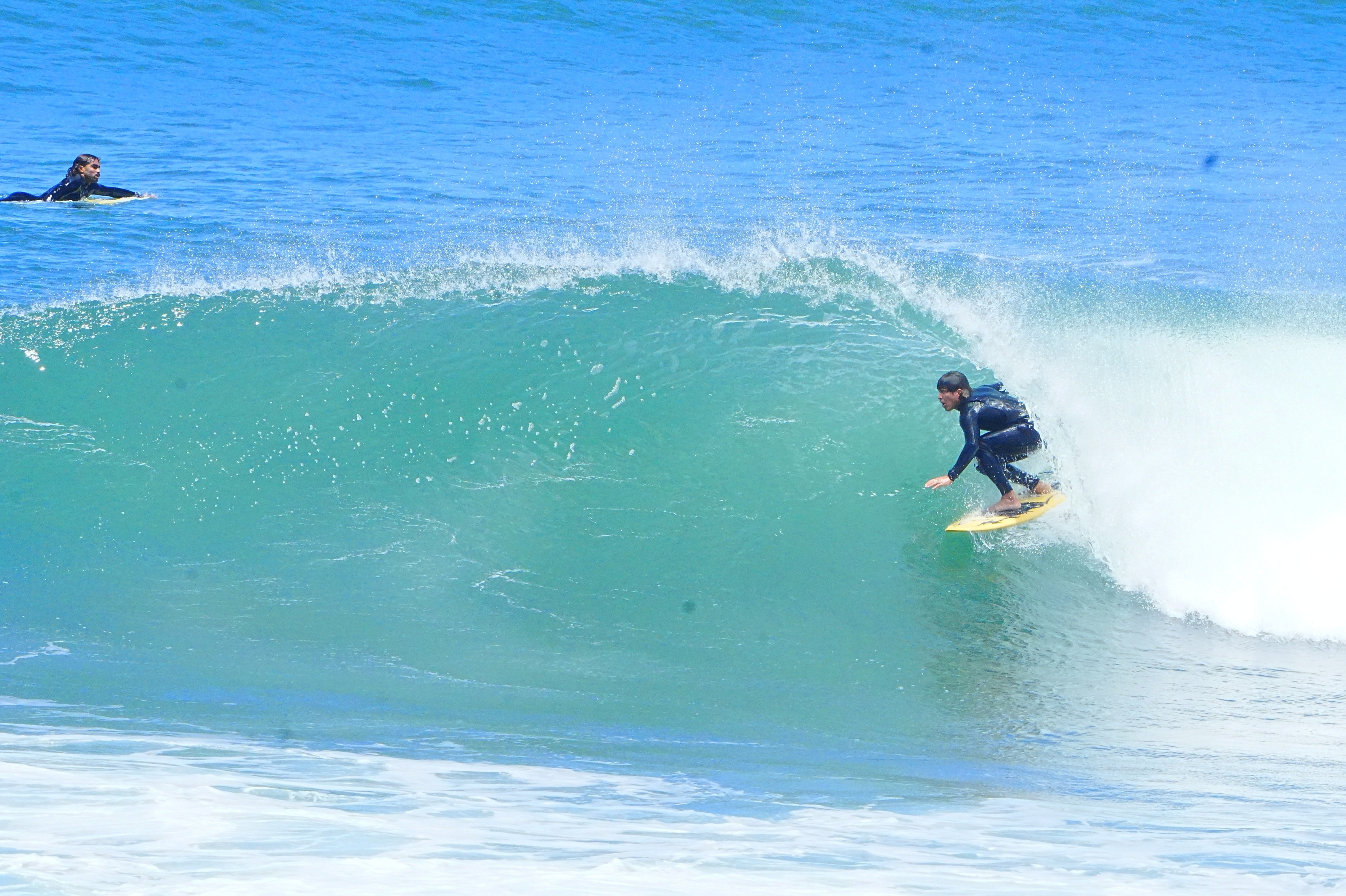 Surfista dentro do tubo, onda turquesa